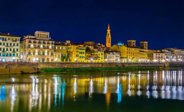 İtalyan kenti Floransa 'nın tarihi merkezinde Arno nehri boyunca uzanan tarihi binaların gece manzarası.