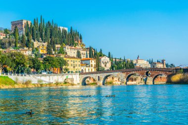 Ponte Pietra Köprüsü 'nün Adige Nehri üzerindeki manzarası ve San Pietro Kalesi İtalyan şehrinin tepesindeki Verona tepesi.