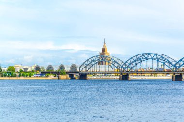 view of the zeppelin hangars and the academy of sciences building next to a steel railway bridge in the Latvian capital Riga