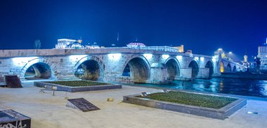 Üsküp, Makedonya, gece ünlü bir taş köprü görünümü
