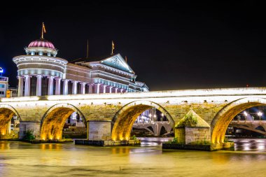 Macar başkenti Skopje 'deki taş köprü ve arkeoloji müzesinin gece görüşü.
