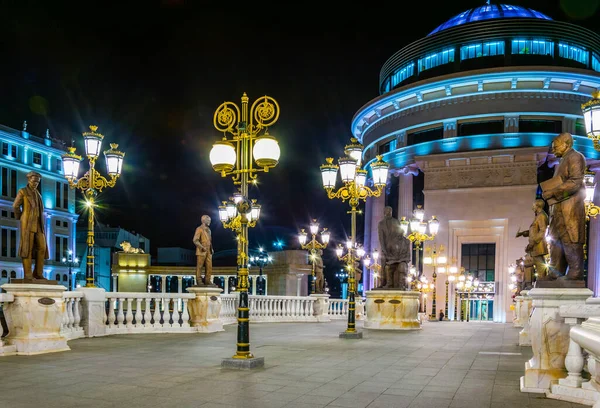 Skopje 'deki Dışişleri Bakanlığı ve Mali Polis Departmanı' na giden köprünün gece görüşü Macedonia ve Fyrom tarihi ile ilgili birçok heykelle süslenmiştir..