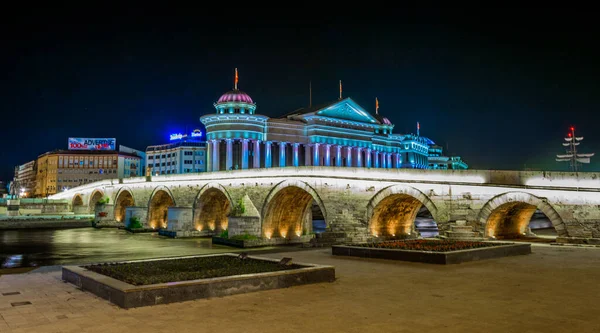 Macar başkenti Skopje 'deki taş köprü ve arkeoloji müzesinin gece görüşü.