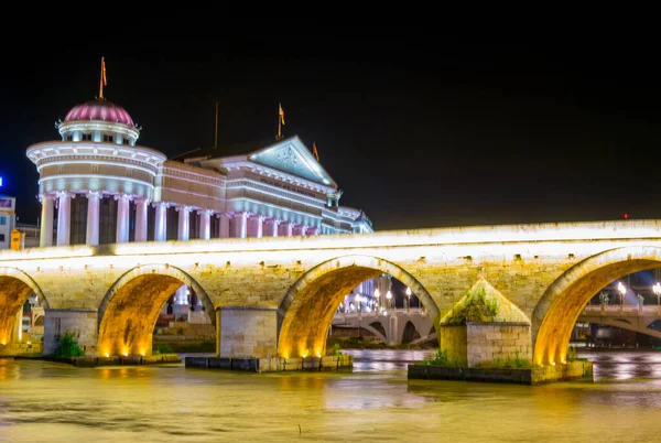 Macar başkenti Skopje 'deki taş köprü ve arkeoloji müzesinin gece görüşü.