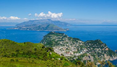 İtalyan tatil adası Capri 'sinin havadan görünüşü iki tepenin üzerine ve aralarında iki küçük şehre yayılmış güzel doğayı birleştiriyor.