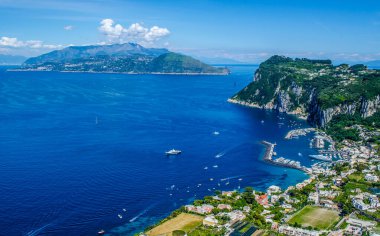 İtalyan tatil adası Capri 'sinin havadan görünüşü iki tepenin üzerine ve aralarında iki küçük şehre yayılmış güzel doğayı birleştiriyor.