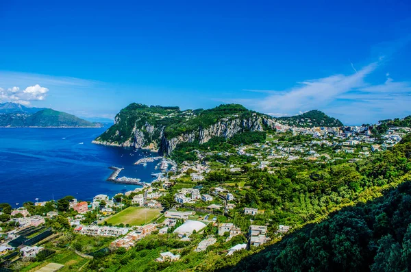 İtalyan tatil adası Capri 'sinin havadan görünüşü iki tepenin üzerine ve aralarında iki küçük şehre yayılmış güzel doğayı birleştiriyor.