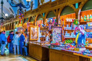 KRAKOW, POLAND, HAZİRAN 11 AĞUSTOS 2016: Krakow, Polonya 'daki Sukiennice Pazar Salonu' ndaki (Kumaş Salonu, Drapers 'Hall) dükkanlar arasında gezinen insanlar