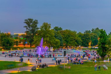 İnsanlar Polonya, Varşova 'daki aydınlık çeşmeleri görmek için Multimedia Fountain Park' ın etrafında toplanıyor..