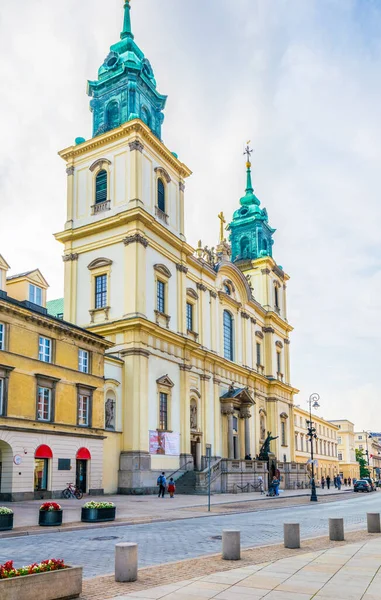 İnsanlar kutsal haç kilisesi, Varşova, Polonya 'nın önündeki swiat caddesinde geziniyorlar.