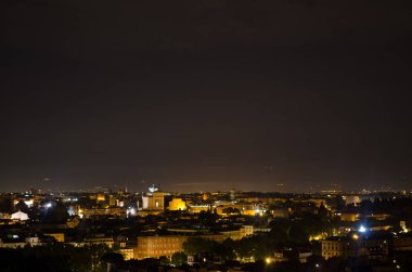 Gianicolo Tepesi 'nin tepesinden çekilen gece manzarası. Ufuktaki en ilginç anıt kar beyazı vittoriano binasıdır..