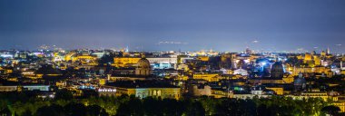 Gianicolo Tepesi 'nin tepesinden çekilen gece manzarası. Ufuktaki en ilginç anıt kar beyazı vittoriano binasıdır..