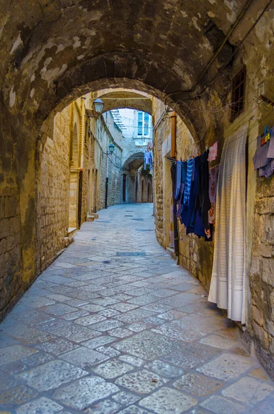 İtalyan şehrinde dar bir cadde görünüyor.