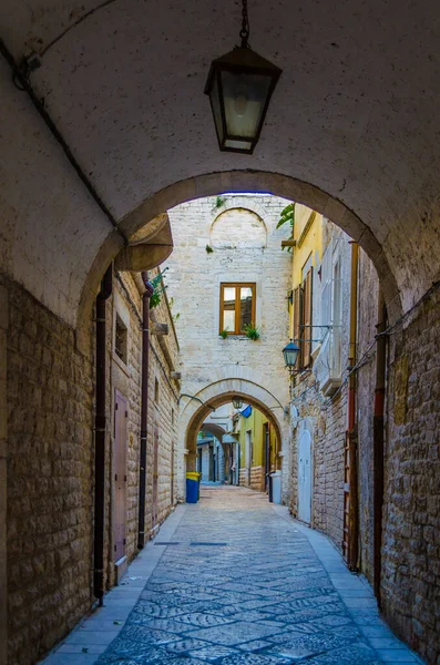 İtalyan şehrinde dar bir cadde görünüyor.