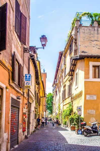 İnsanlar, İtalya 'nın başkenti Roma' nın Trastevere bölgesinin dar sokaklarında geziniyorlar, ki bu da yerel gece hayatı, turizm ve lezzetli mutfağın merkezidir..