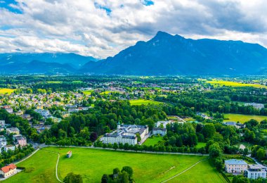 Avusturya 'nın Salzburg kentinde bir banliyö manzarası. Aile evleri ormanlar, çayırlar ve tepelerle çevrili.