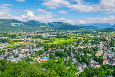 Avusturya 'nın Salzburg kentinde bir banliyö manzarası. Aile evleri ormanlar, çayırlar ve tepelerle çevrili.