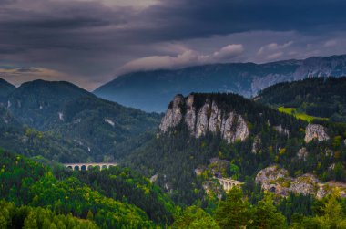 Krauselklause, Polleroswand 'ın önündeki demiryolunu çevreleyen dağ manzarasıyla donatır. Arka planda karlı Rax dağ sırası var. Breitenstein am Semmering, Aşağı Avusturya, Avusturya