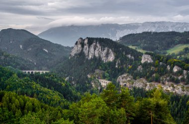 Krauselklause, Polleroswand 'ın önündeki demiryolunu çevreleyen dağ manzarasıyla donatır. Arka planda karlı Rax dağ sırası var. Breitenstein am Semmering, Aşağı Avusturya, Avusturya