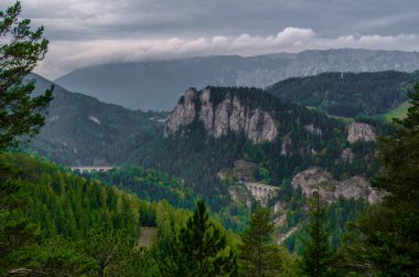 Krauselklause, Polleroswand 'ın önündeki demiryolunu çevreleyen dağ manzarasıyla donatır. Arka planda karlı Rax dağ sırası var. Breitenstein am Semmering, Aşağı Avusturya, Avusturya