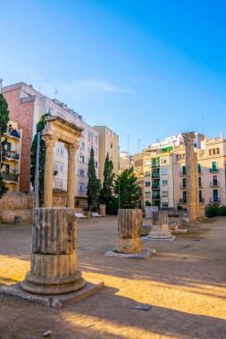 Roma forumunun sütunları Tarragona, Katalonya, İspanya 'daki modern binalarla çevrili.