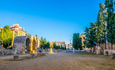 Roma forumunun sütunları Tarragona, Katalonya, İspanya 'daki modern binalarla çevrili.