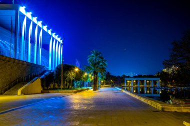 Palau de la musica de valencia konser salonunun gece boyunca bir gölete yansıyan görüntüsü.