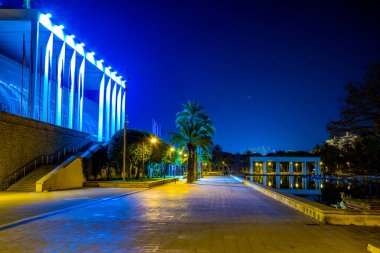 Palau de la musica de valencia konser salonunun gece boyunca bir gölete yansıyan görüntüsü.