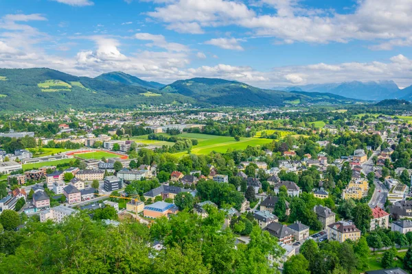 Avusturya 'nın Salzburg kentinde bir banliyö manzarası. Aile evleri ormanlar, çayırlar ve tepelerle çevrili.