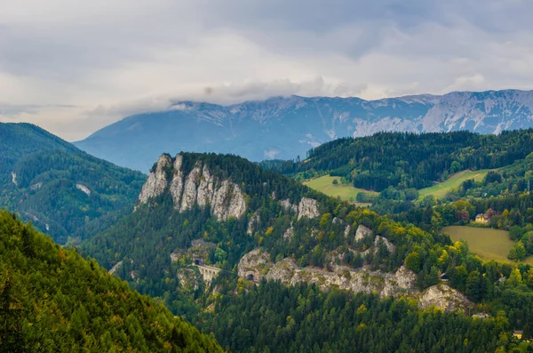 Krauselklause, Polleroswand 'ın önündeki demiryolunu çevreleyen dağ manzarasıyla donatır. Arka planda karlı Rax dağ sırası var. Breitenstein am Semmering, Aşağı Avusturya, Avusturya