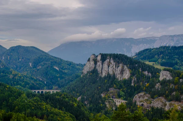 Krauselklause, Polleroswand 'ın önündeki demiryolunu çevreleyen dağ manzarasıyla donatır. Arka planda karlı Rax dağ sırası var. Breitenstein am Semmering, Aşağı Avusturya, Avusturya