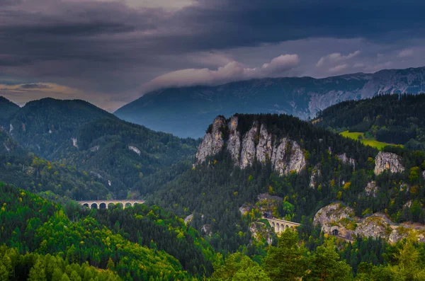 Krauselklause, Polleroswand 'ın önündeki demiryolunu çevreleyen dağ manzarasıyla donatır. Arka planda karlı Rax dağ sırası var. Breitenstein am Semmering, Aşağı Avusturya, Avusturya