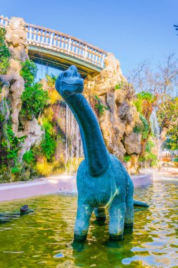 Cadiz 'deki genov parkında yapay bir kayanın önündeki bir dinozor heykeli.