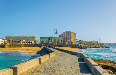 İspanyol şehri Cadiz 'deki San Sebastian şatosuna giden dar bir tuğla yol.