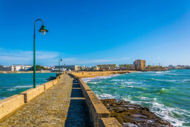 İspanyol şehri Cadiz 'deki San Sebastian şatosuna giden dar bir tuğla yol.