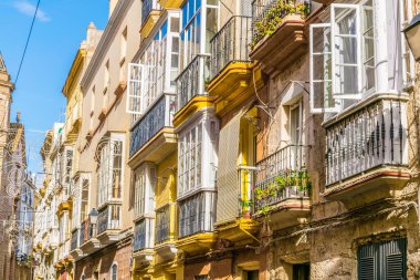 view of a row of balconies on a narrow street in historical center of spanish city cadiz