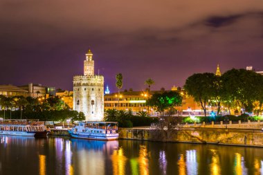 Guadalquivir nehri boyunca uzanan Altın Kule 'nin (Torre del Oro) gece görüşü, Sevilla (Endülüs), İspanya.