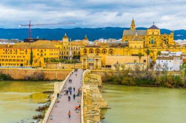 aerial view of the roman bridge in the spanish city cordoba with the la mezquita cathedral at background