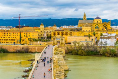 aerial view of the roman bridge in the spanish city cordoba with the la mezquita cathedral at background