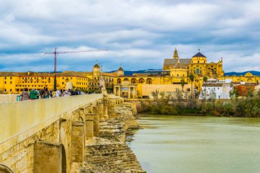 İnsanlar İspanya 'nın Cordoba şehrindeki Roma köprüsünden geçerek La mezquita katedraline doğru yürüyorlar..