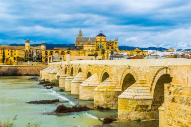İnsanlar İspanya 'nın Cordoba şehrindeki Roma köprüsünden geçerek La mezquita katedraline doğru yürüyorlar..