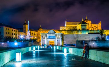 İnsanlar İspanya 'nın Cordoba şehrindeki Roma köprüsünden geçerek La mezquita katedraline doğru yürüyorlar..