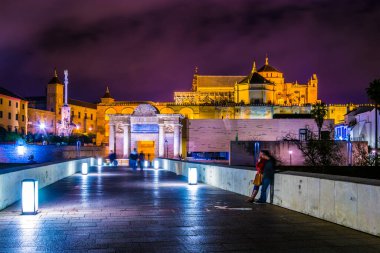 İnsanlar İspanya 'nın Cordoba şehrindeki Roma köprüsünden geçerek La mezquita katedraline doğru yürüyorlar..