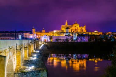 İspanya 'nın Cordoba kentindeki Guadalquivir nehri üzerindeki aydınlık Roma köprüsünün gece görüşü.