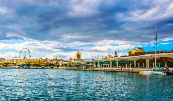 İspanyol şehri Malaga 'da beyaz dalgaya benzeyen bir yapının altında uzanan paseo del muelle dos gezinti
