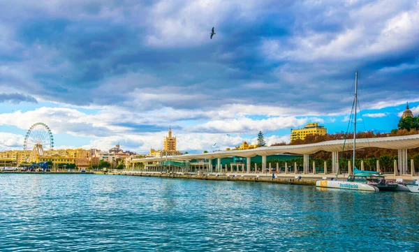 İspanyol şehri Malaga 'da beyaz dalgaya benzeyen bir yapının altında uzanan paseo del muelle dos gezinti