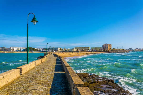 İspanyol şehri Cadiz 'deki San Sebastian şatosuna giden dar bir tuğla yol.