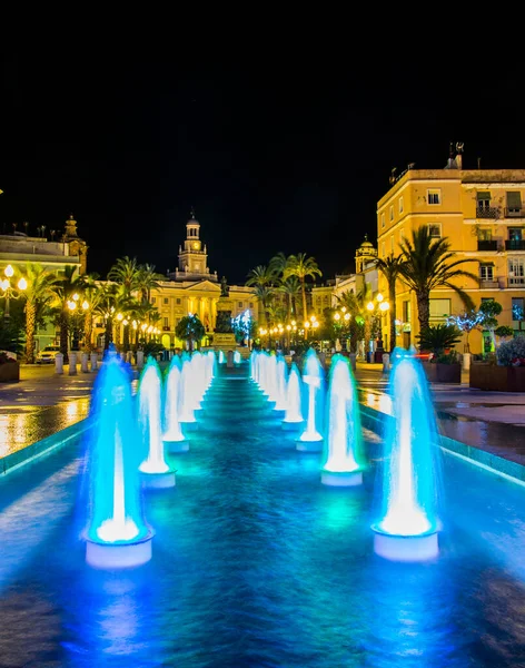 Cadiz 'de Aziz John Meydanı' ndaki bir çeşmenin gece görüşü. Arka planda belediye binası var.