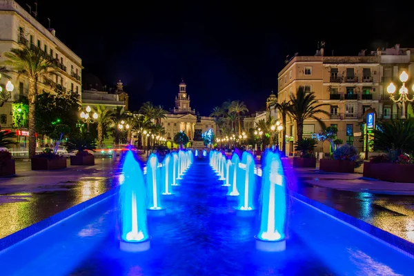 Cadiz 'de Aziz John Meydanı' ndaki bir çeşmenin gece görüşü. Arka planda belediye binası var.