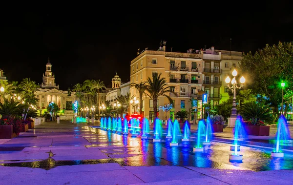 Cadiz 'de Aziz John Meydanı' ndaki bir çeşmenin gece görüşü. Arka planda belediye binası var.